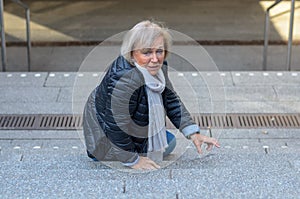 Helpless senior woman falling down steps