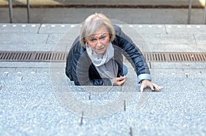 Helpless senior woman falling down steps