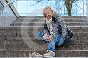 Helpless senior woman massaging her Foot