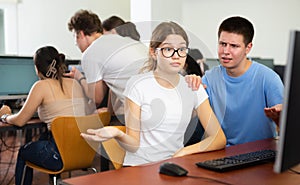 Helpless teenager boy and girl studying in computer class