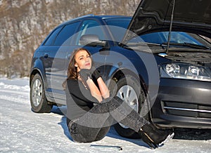 helpless woman sitting near broken car