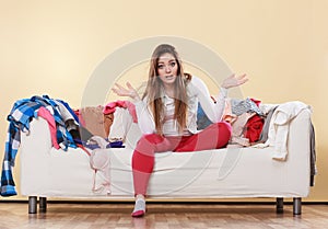 Helpless woman sitting on sofa in messy room home.