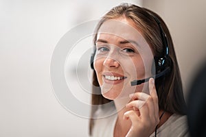 Helpline female operator with headphones in call centre.Business woman with headsets working in a call center. Selective