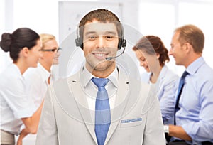 Helpline operator with headphones in call centre