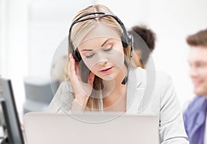 Helpline operator with headphones in call centre photo