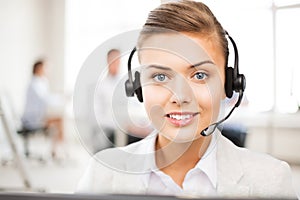 Helpline operator with headphones in call centre photo