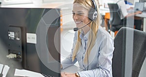 Helpline operator woman with headphones in call centre.