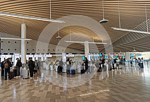 Travellers check-in luggage on departure terminal gate in an International airport.