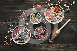 Helthy breakfast. Delicious smoothie bowls with fruits, berries and seeds on the wooden background.