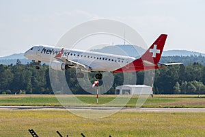 Helvetic Airways Embraer E-190LR jet is landing on runway 14 in Zurich in Switzerland