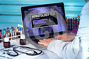Hematology Test. doctor in lab examining blood sample in laptop photo