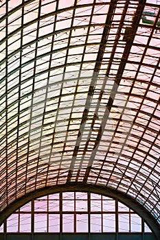 A hemispherical ceiling of glass and metal in modern building on a background of orange sunlight