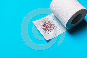 Hemorrhoids treatment concept, toilet paper on a blue background