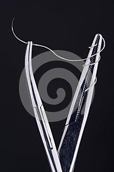 Hemostats holding Suture Kit