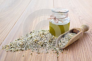 Hemp oil in a glass jar and hemp seeds in a wooden spoon