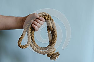 Hemp rope scroll with a knot in a male hand