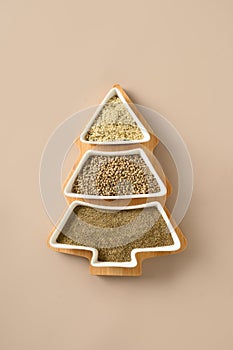 Hemp seeds, flour, kernels in plate shape of Christmas tree. Xmas vertical eco greeting card. Xmas tree.