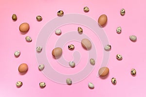 Hen brown eggs and quail eggs on pink background, copy space. Healthy food concept. Top view, flat lay. Easter eggs. Happy Easter