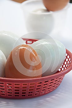 Hen egg and salted egg in plastic basket