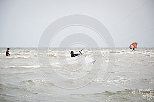 Henichesk, Ukraine - July 12, 2021: Kitesurfing. Extreme sport and watersport in summer. Paragliding and wakeboarding. Man rides a