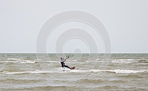 Henichesk, Ukraine - July 12, 2021: Ocean with kiteboarder riding kiteboard. Watersport adrenaline adventure activity. Kitesurfing