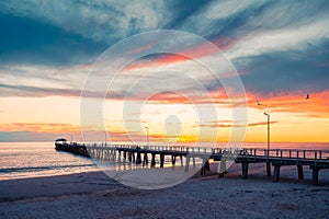 Henley Beach jetty at dusk with the tranquil sea embracing the weathered pillars