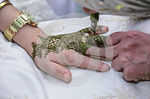 Henna being applied to hand of an MOROCCAN bride