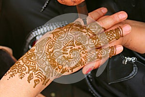 Henna being applied to woman's hand