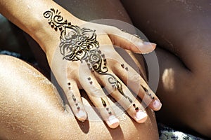 Henna tattoo drawing mehendi on girl& x27;s hand