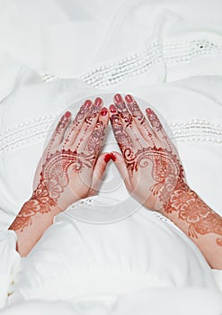 Henna tattoo on hands holding on white dress