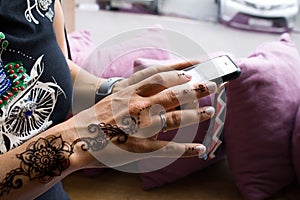 henna tattoo on women hands. Mehndi is traditional Indian decorative art. Close-up, overhead view - beauty and fashion concept