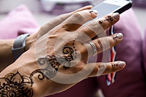 henna tattoo on women hands. Mehndi is traditional Indian decorative art. Close-up, overhead view - beauty and fashion concept
