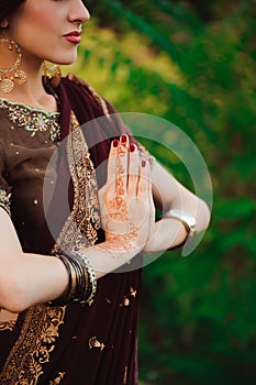 Henna wedding design, Woman Hands with black mehndi tattoo. Hands of Indian bride girl with black henna tattoos. Fashion