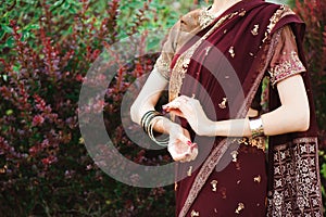 Henna wedding design, Woman Hands with black mehndi tattoo. Hands of Indian bride girl with black henna tattoos. Fashion