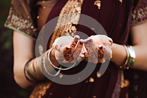 Henna wedding design, Woman Hands with black mehndi tattoo. Hands of Indian bride girl with black henna tattoos. Fashion
