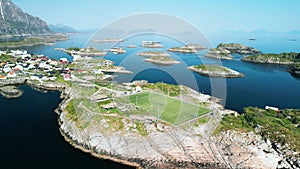 Henningsvaer Stadium in Lofoten Islands, Norway. The drone flies smoothly back showing a panorama of the sea