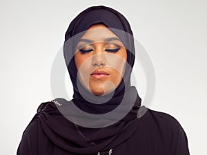 Her beauty is the connection she has with her religion. Studio shot of a young muslim woman with her eyes closed.
