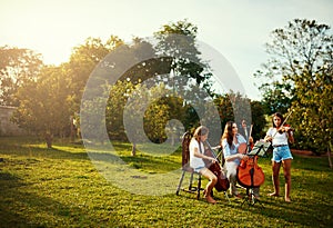 Her favourite part of the week, practicing with her girls. a beautiful mother playing instruments with her adorable