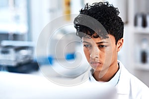 Her focus never falters. a young scientist working on a computer in a lab.