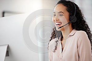 Her interaction with customers is always positive. Shot of a young call centre agent working on a computer in an office.