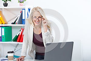 Her job is her life. Business woman with glasses working in office with documents. Beautiful middle aged woman looking