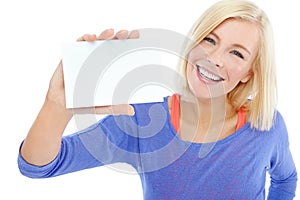 Her lovely smile alongside your product. A beautiful young woman holding a blank card while isolated on a white