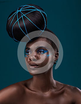Her makeup game is strong. Studio shot of a beautiful young woman posing against a dark background.