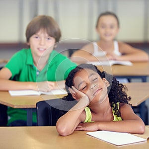 Her minds in another place entirely. A little girl daydreaming during a school lesson.