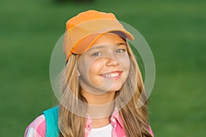 Her new favorite look. Happy kid with beauty look. Fashion look of little hipster. Hip hop girl smile on green grass