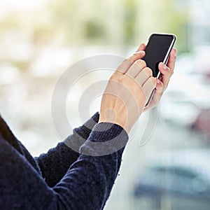 Her office is wherever she is. an unidentifiable businesswoman using a smartphone ouside.