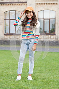 In her own style. childhood happiness. happy girl with long curly hair. pretty child smiling outdoor. kid beauty and