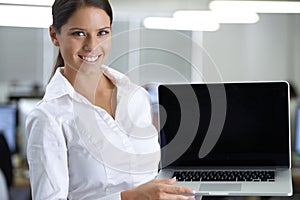 Her positivity keeps the office in great spirits. Portrait of an attractive young businesswoman holding a laptop.