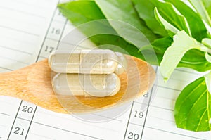 Herb capsule with green herbal leaf