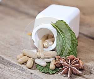 Herb capsule spilling out of a bottle